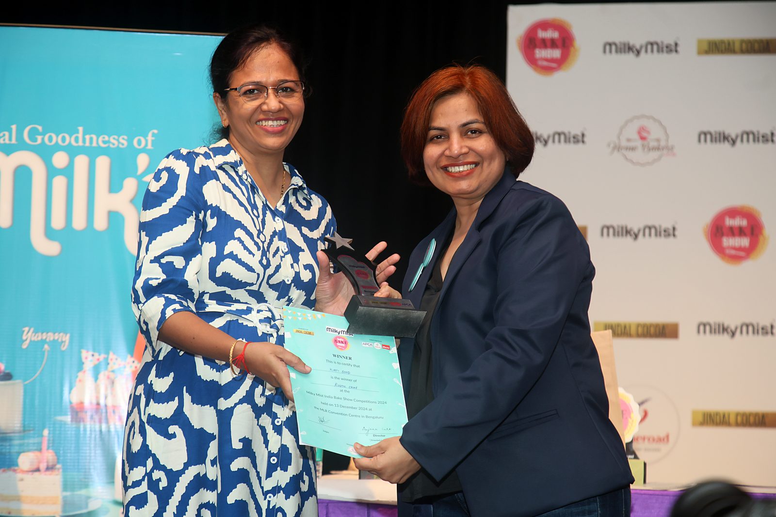A competition winner holding her prize on stage